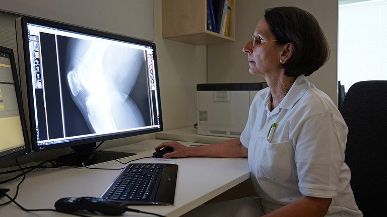 Ärztin schaut sich Röntgenaufnahmen des Knies auf dem Monitor an, Immanuel Albertinen zentrum für Radiologie, Standort Hamburg-Schnelsen